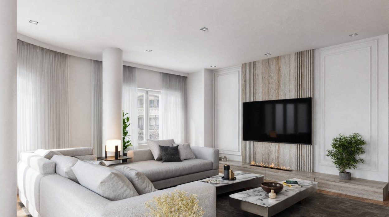 Proyecto de interiorismo residencial y reforma integral de lujo en Bilbao y Donostia por CTEstudio. Salón moderno con sofá modular gris, mesas de centro de mármol, chimenea integrada de diseño y panel de madera para televisión.